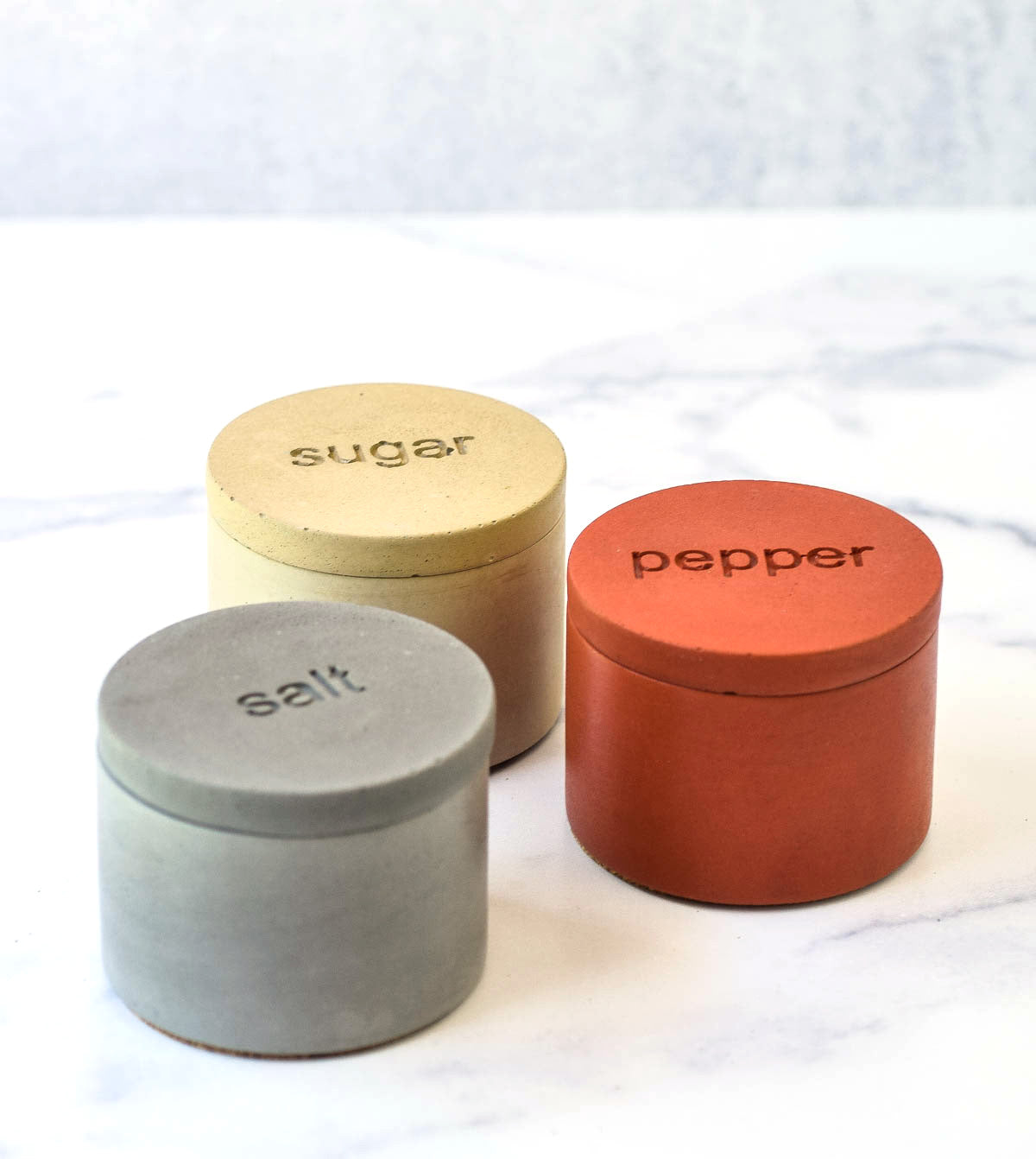 gray salt cellar, poppy pepper cellar and chartreuse sugar cellar all will lids on.